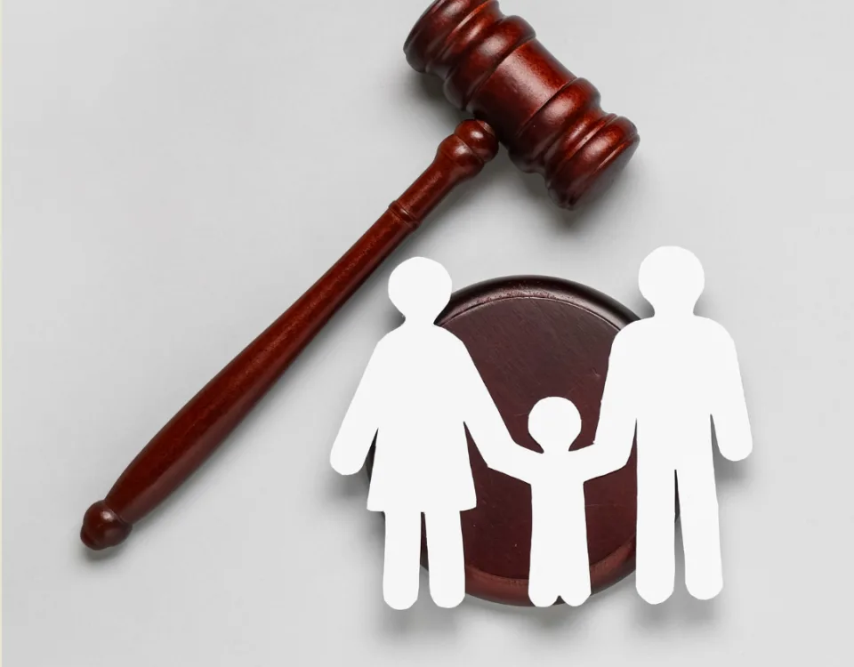An image showing a judges' gavel with a paper cut-out of a family.